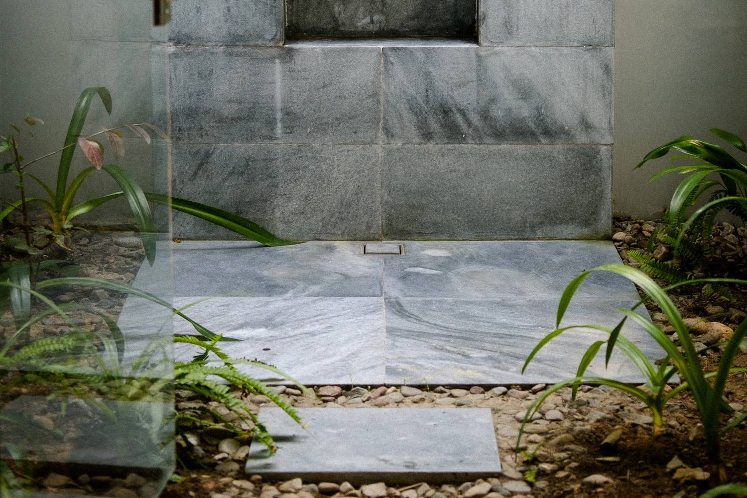 An empty open-sided treatment pavilion facing a tropical garden.