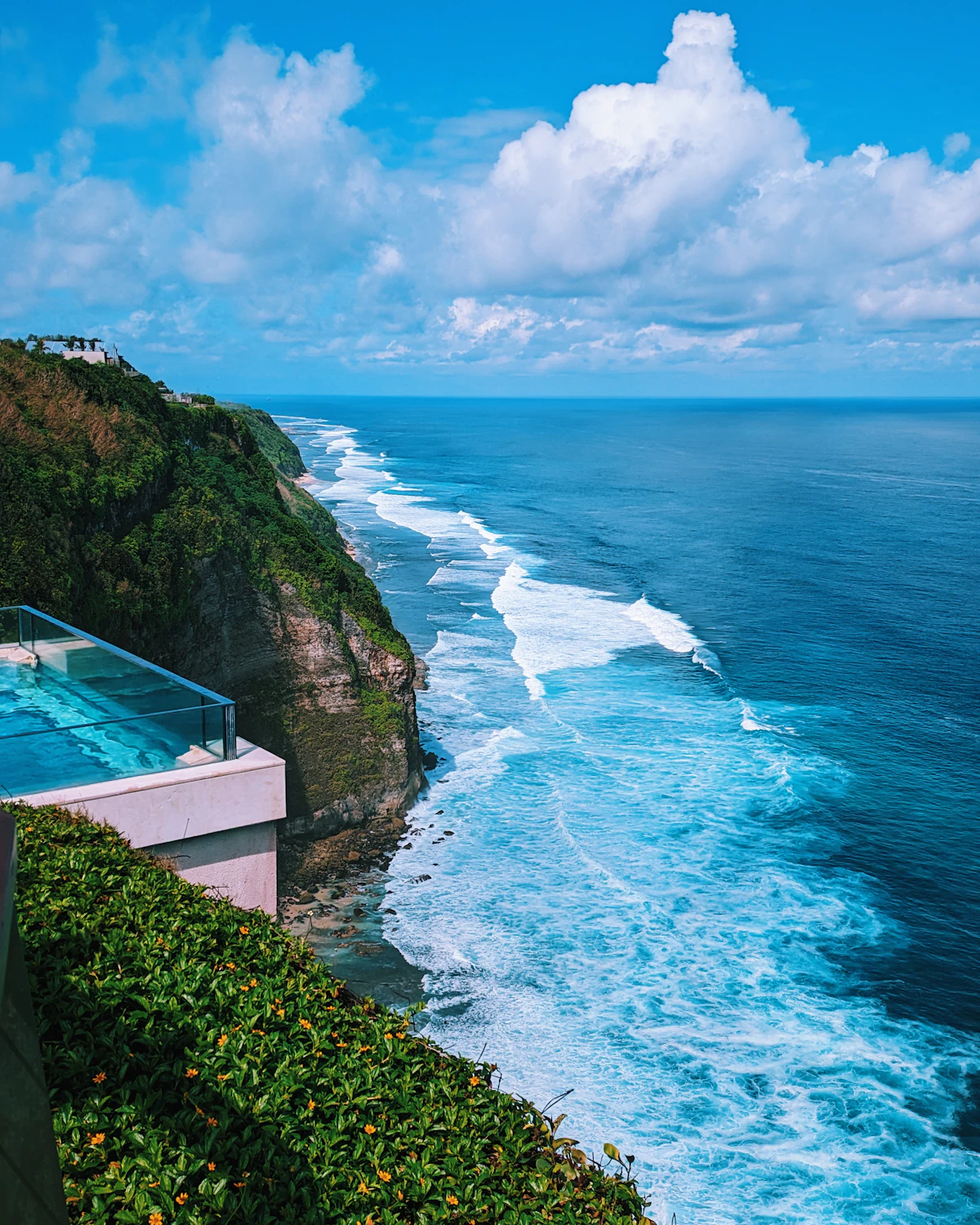 A private plunge pool cut into dark volcanic stone on a terrace above the sea.
